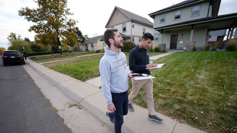Vote canvassers Zach Martinez, front, and Joshua Posner check their itinerary while making...