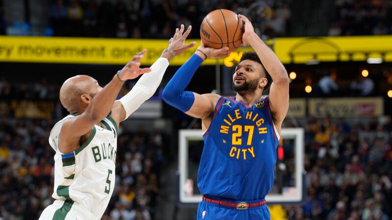 Denver Nuggets guard Jamal Murray, right, shoots for a 3-point basket over Milwaukee Bucks...