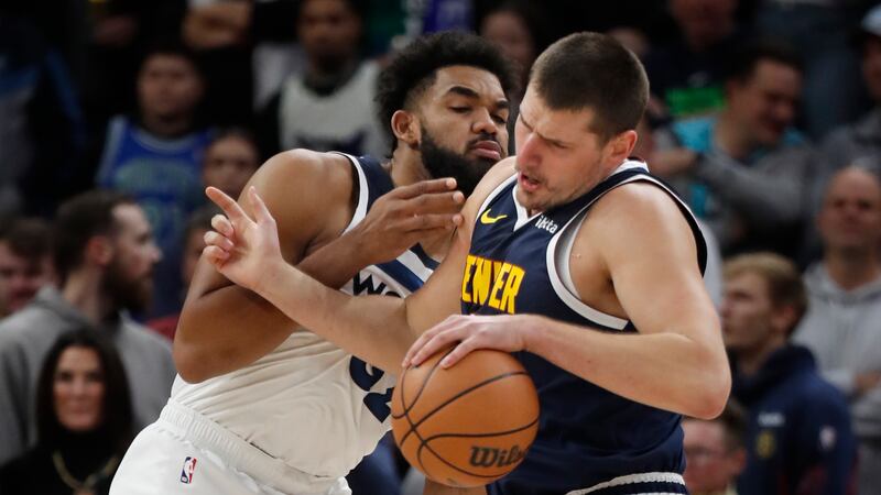 Denver Nuggets center Nikola Jokic, right, works against Minnesota Timberwolves forward...