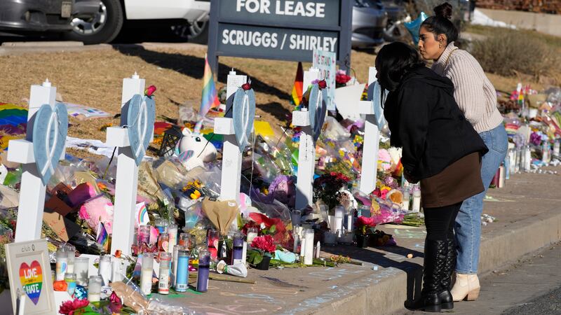 Mourners stand along the makeshift memorial to the victims of a weekend mass shooting at a...