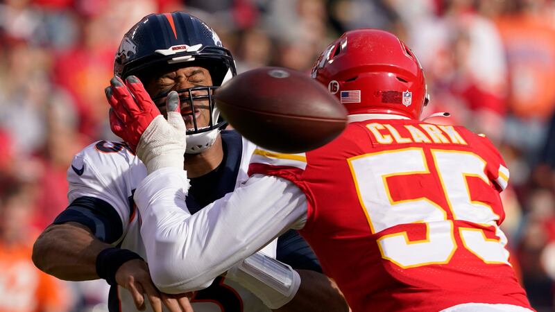Denver Broncos quarterback Russell Wilson, left, is hit by Kansas City Chiefs defensive end...