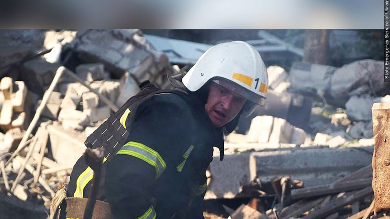 A first responder works through the ruins of a building destroyed by Russian rocket strikes in...