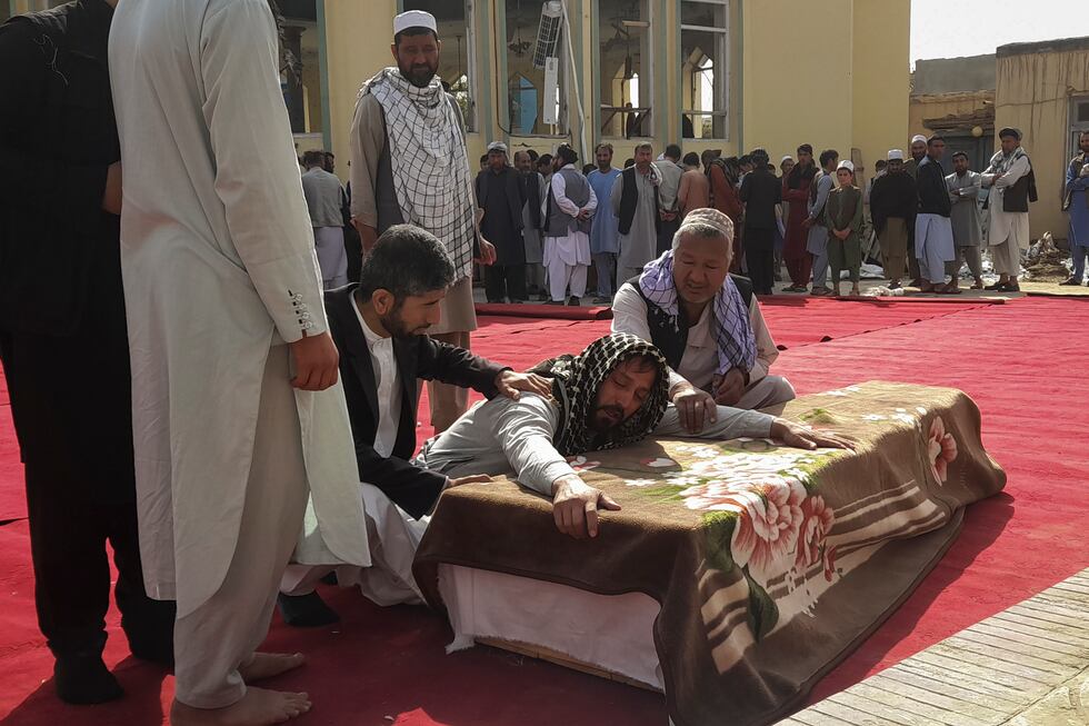 Relatives and residents attend a funeral ceremony for victims of a suicide attack at the...